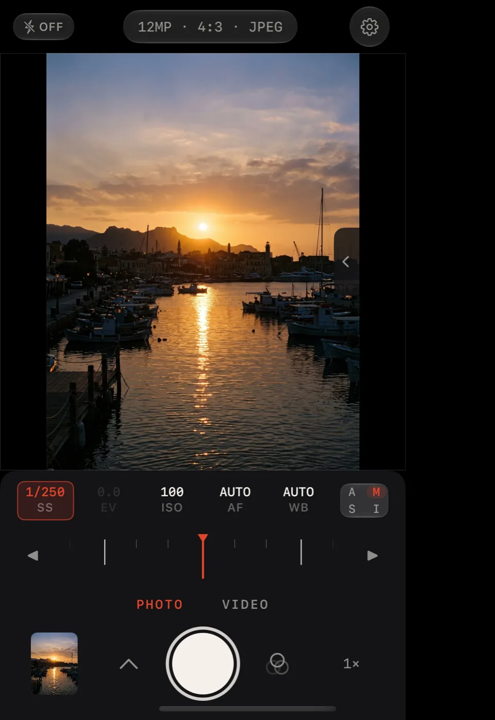 Lucid Camera on iPhone Duo closed outer display in Manual mode with the shutter speed dial selected under a harbor photo
