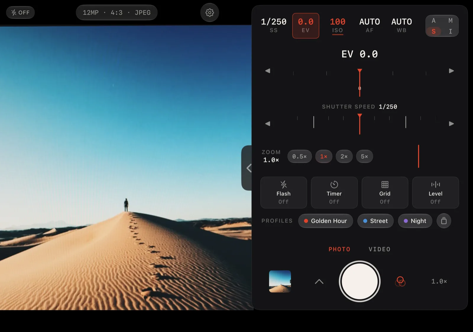 Lucid Camera on iPhone Duo open display showing a desert dune in the viewfinder and the shutter-priority grip with exposure compensation and shutter speed dials